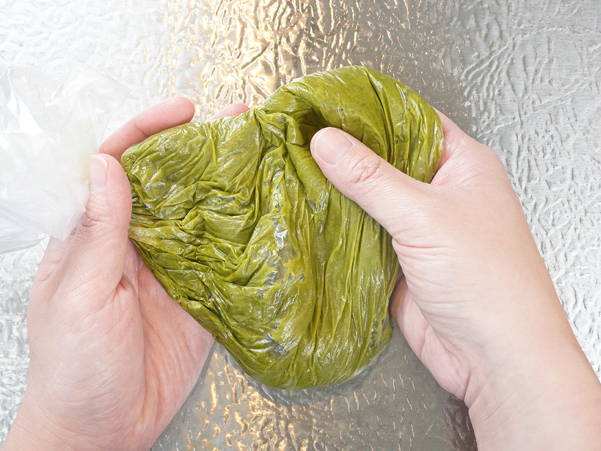 卵を混ぜた後、薄力粉と抹茶パウダーを入れて揉み込むシーン