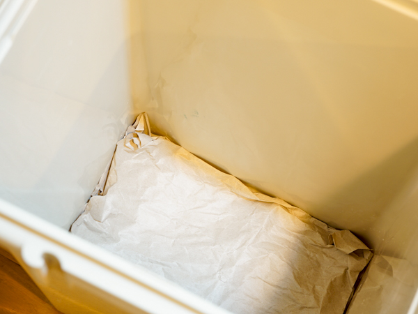 ゴミ箱の底に古紙を敷く様子