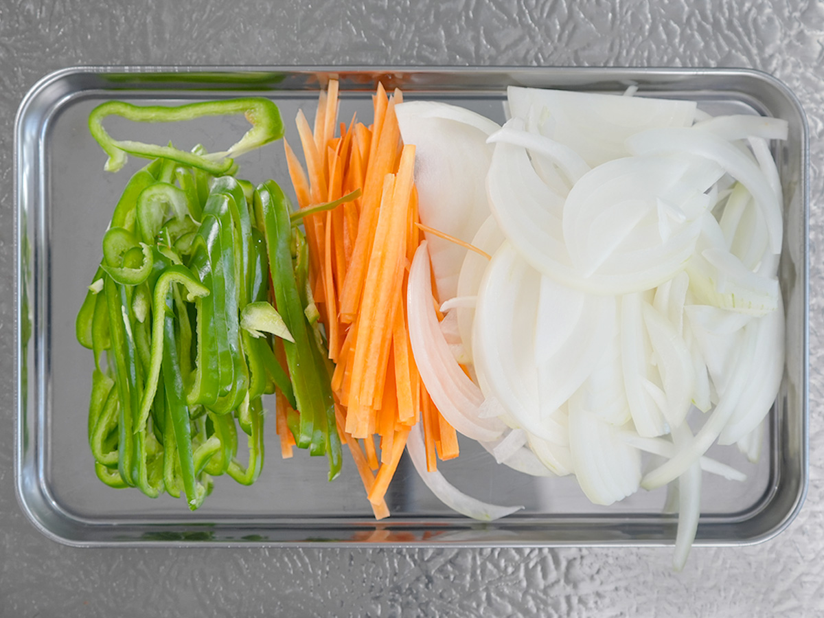 玉ねぎを薄切り、にんじんとピーマンは細ぎりにしたシーン