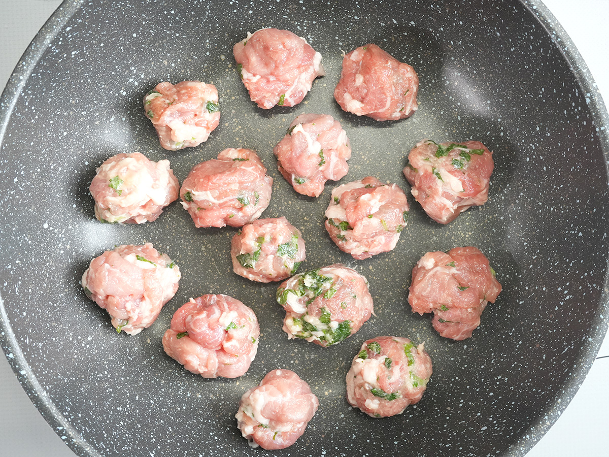 ひと口大の大きさに豚こま肉を丸めてフライパンに並べるシーン
