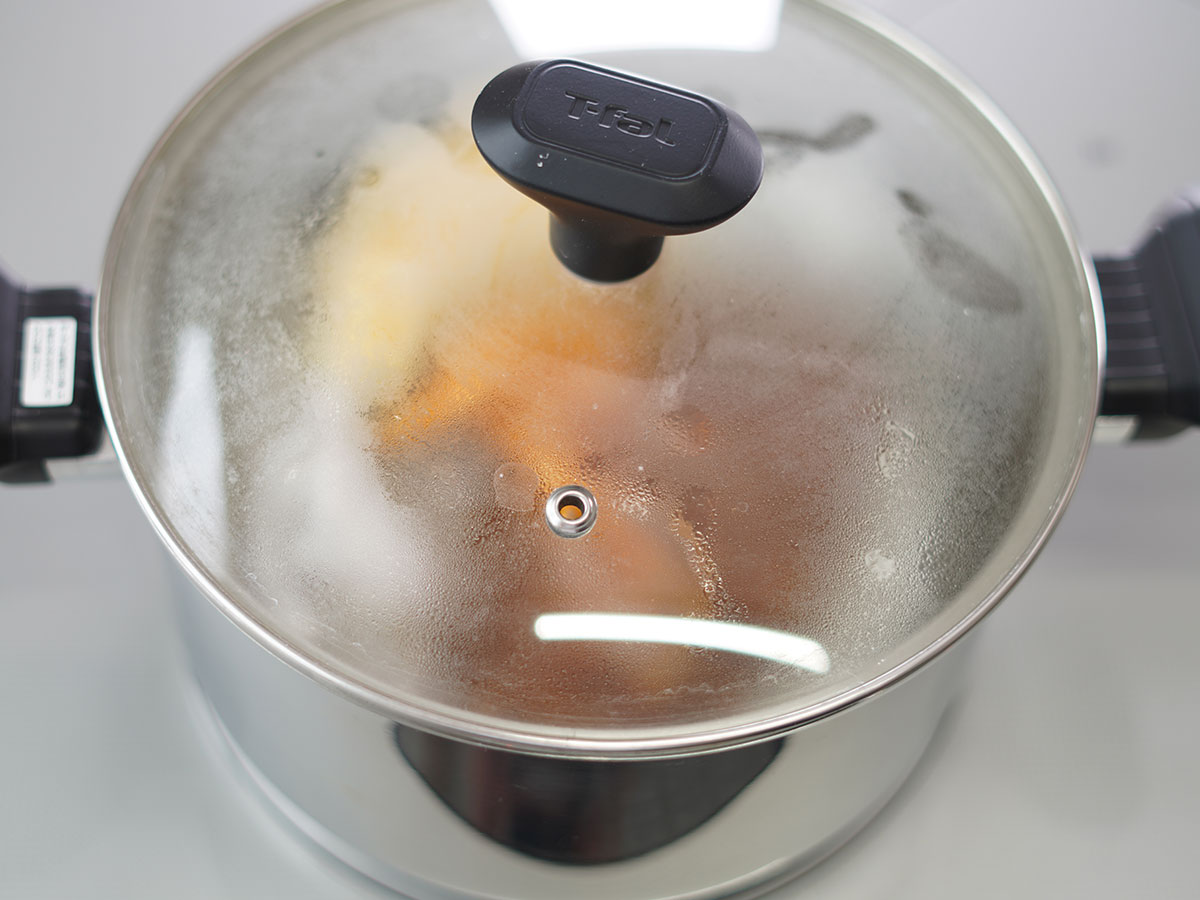 ポリ袋に入れたハッシュドビーフソースとオムレツを湯せんしている様子