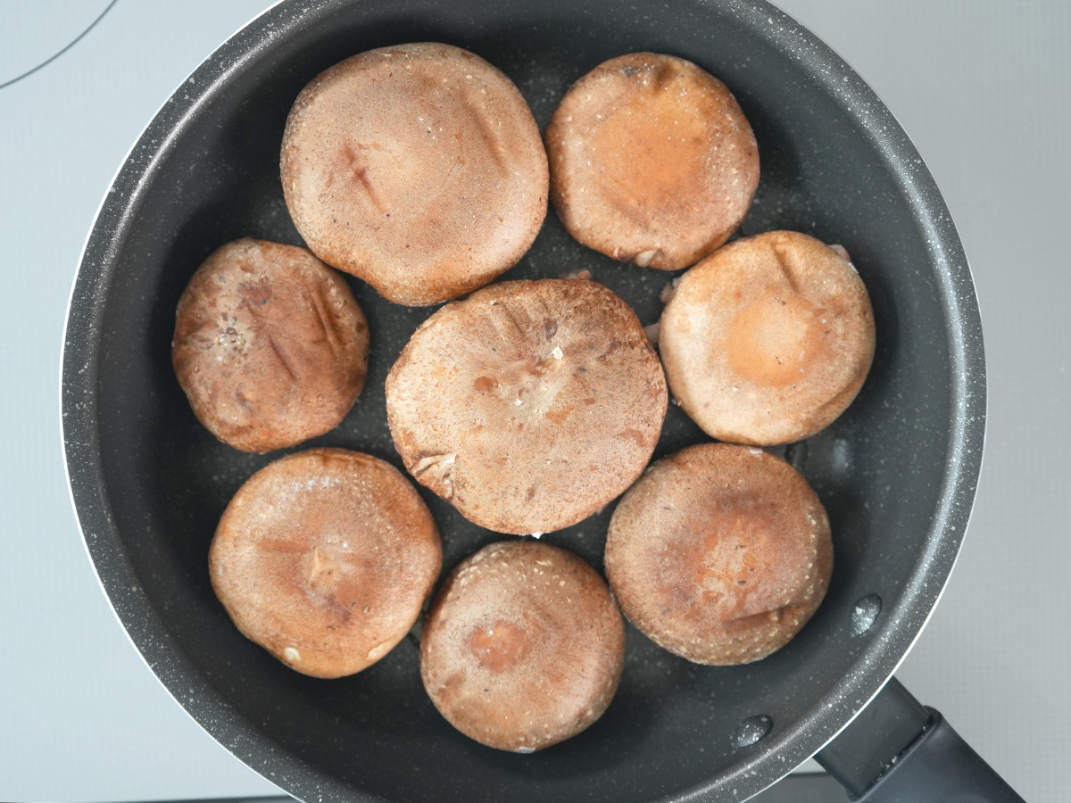 フライパンにごま油を熱し、肉の面を下にして焼くシーン