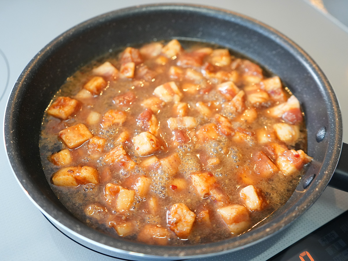 沸騰したコーラに豚肉を入れて煮込むシーン