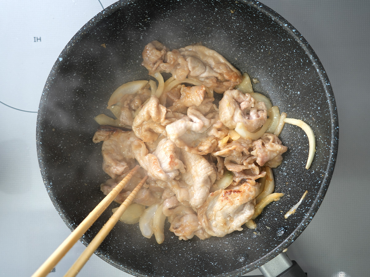 豚肉と玉ねぎを炒めるシーン
