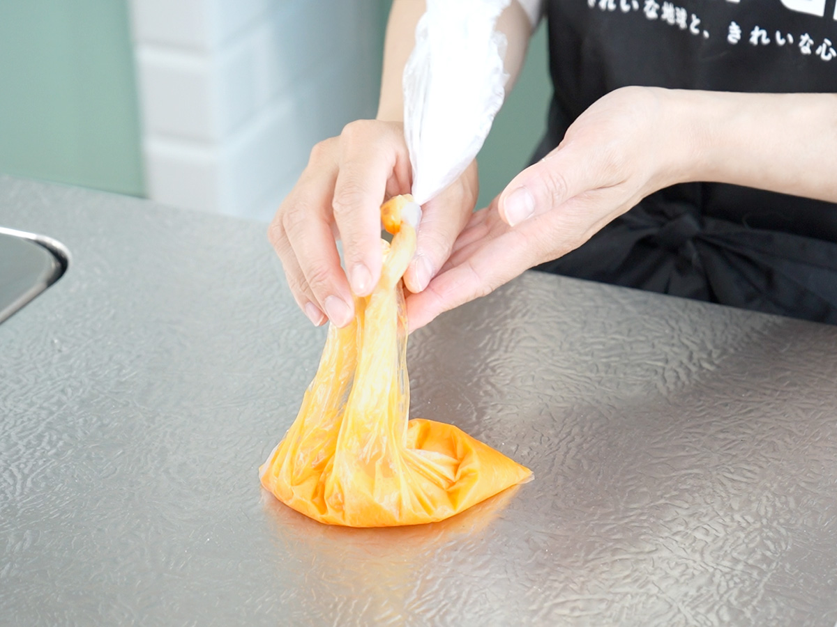 ポリ袋を入れて湯せんするシーン