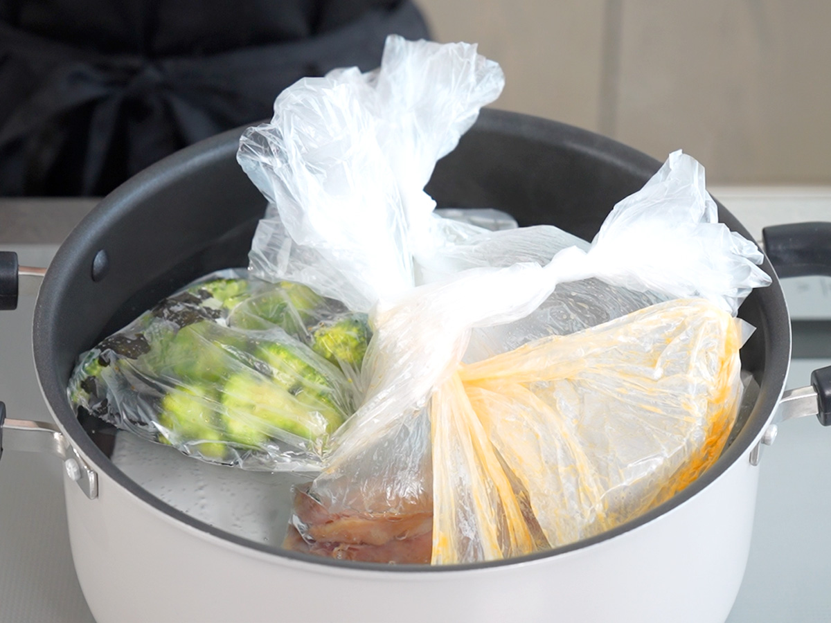 ポリ袋を入れて湯せんするシーン