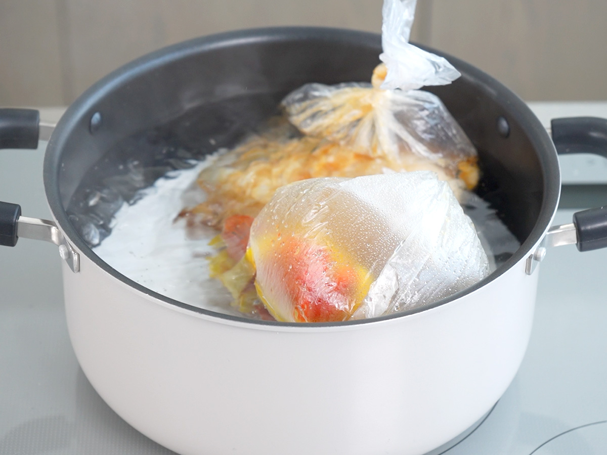 ポリ袋を入れて湯せんするシーン