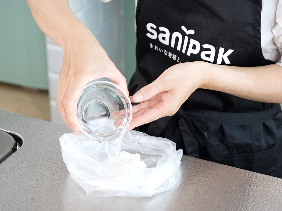 ポリ袋1にご飯と水を入れるシーン