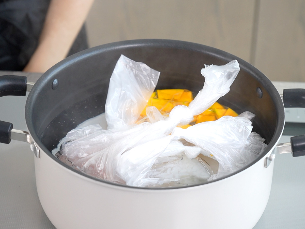 ポリ袋を入れて湯せんするシーン