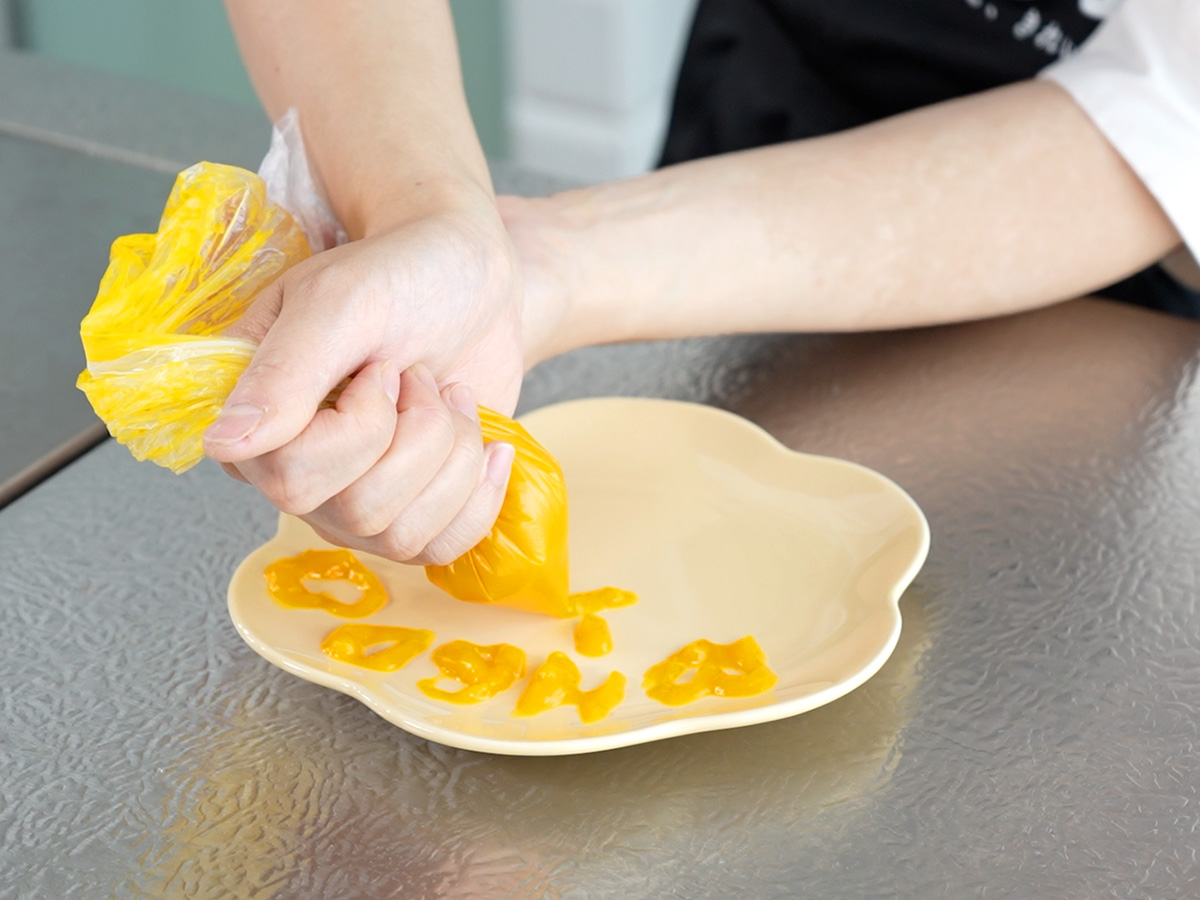 ポリ袋の底の先端を切って絞り出すシーン