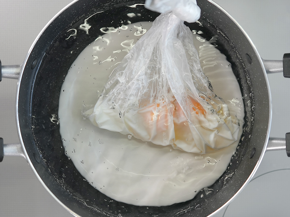ポリ袋の空気を抜いて縛り、沸騰した湯につけて弱火で9~10分ほど湯せんするシーン