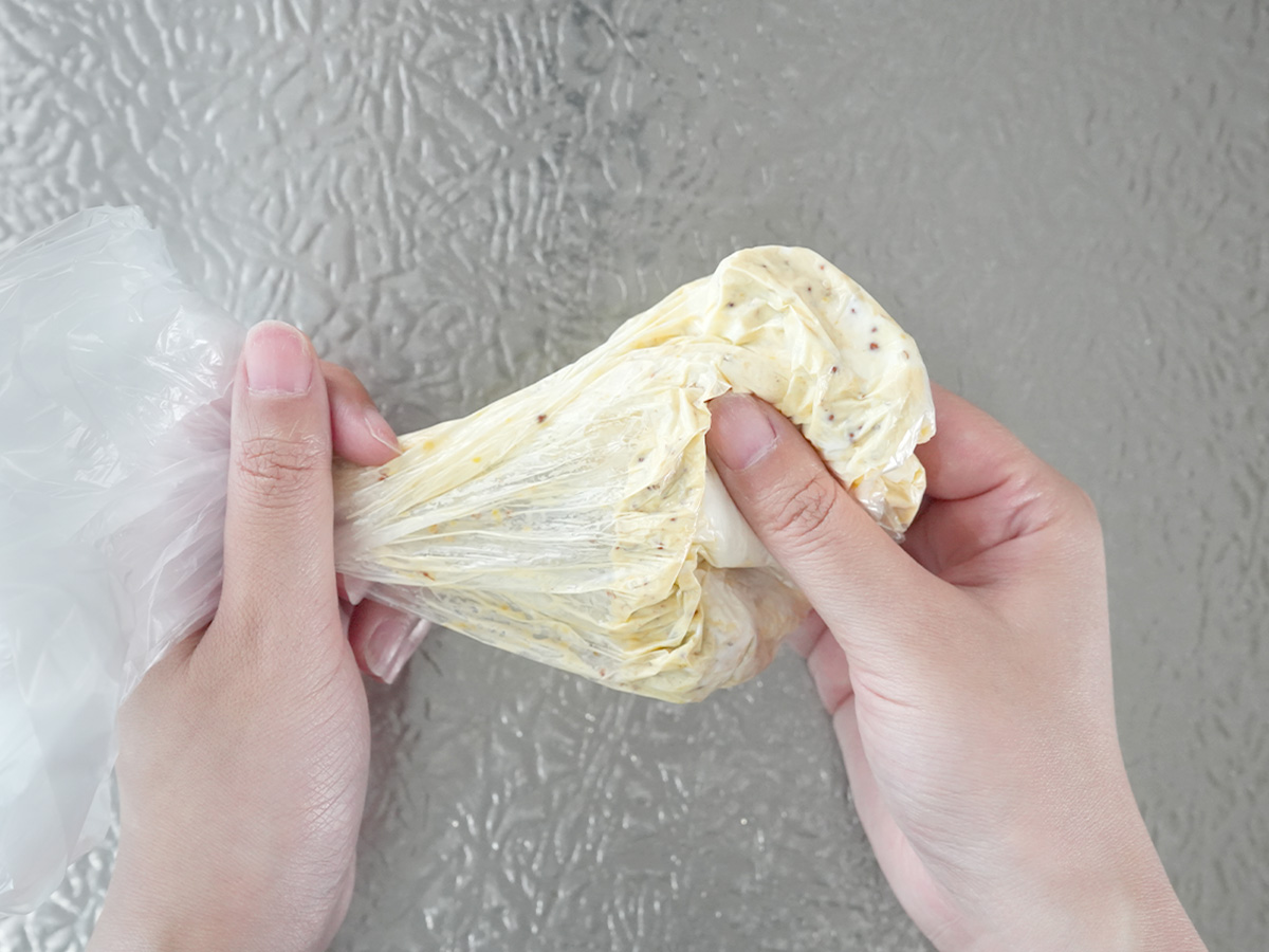 ポリ袋を揉み込んで調味料を混ぜるシーン