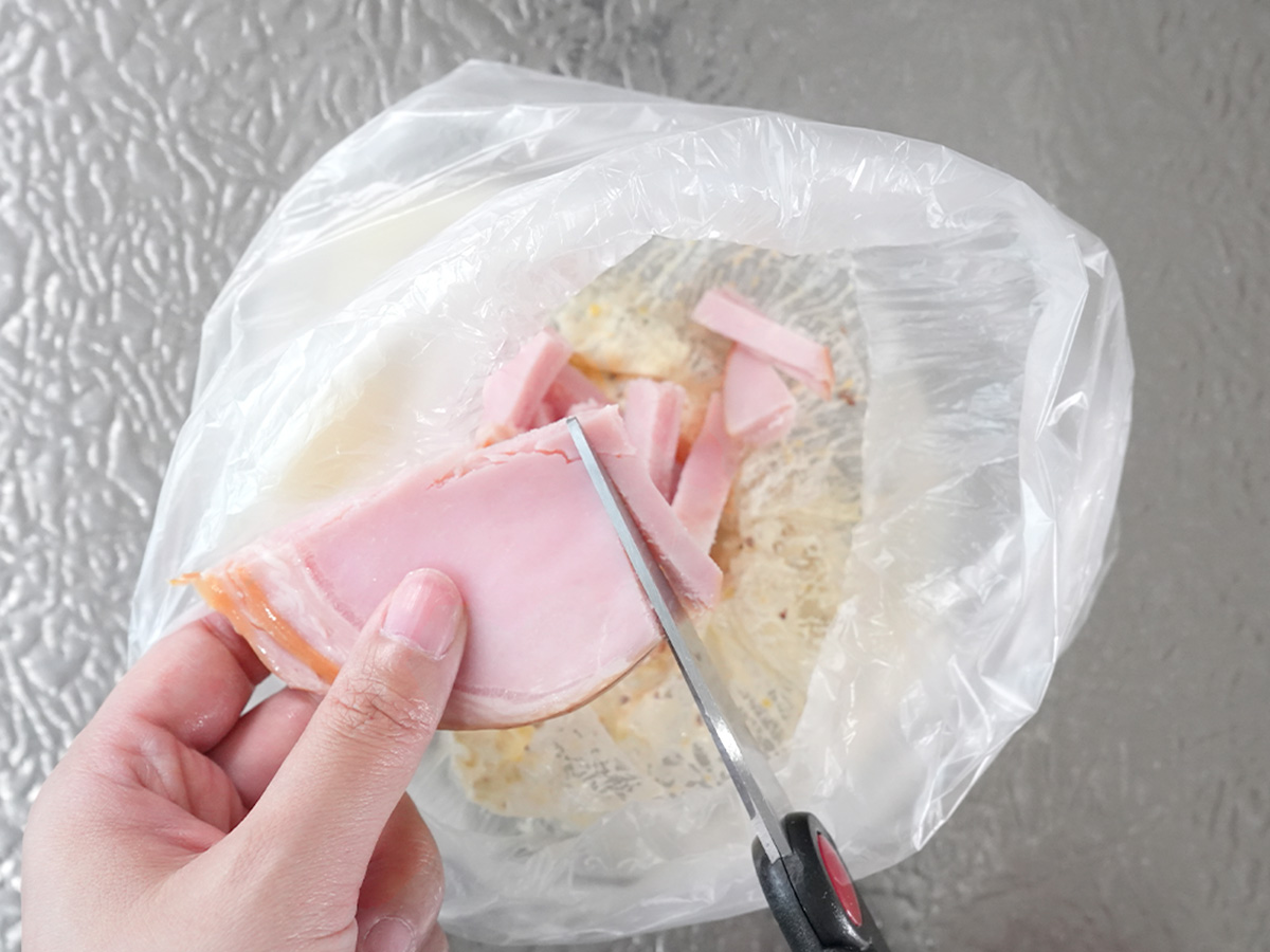 ポリ袋にハムを切りながら加えるシーン