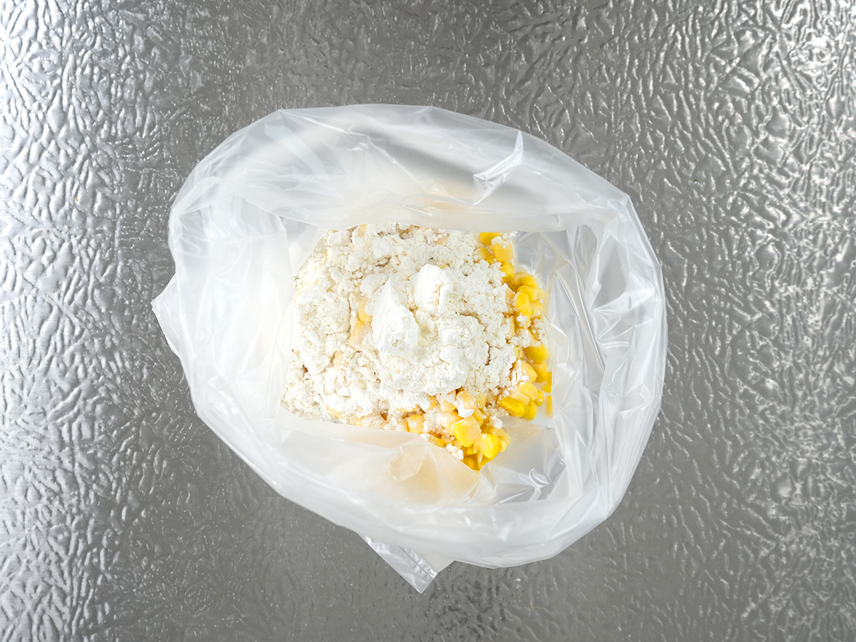 ポリ袋にAのコーン、薄力粉、牛乳を入れるシーン