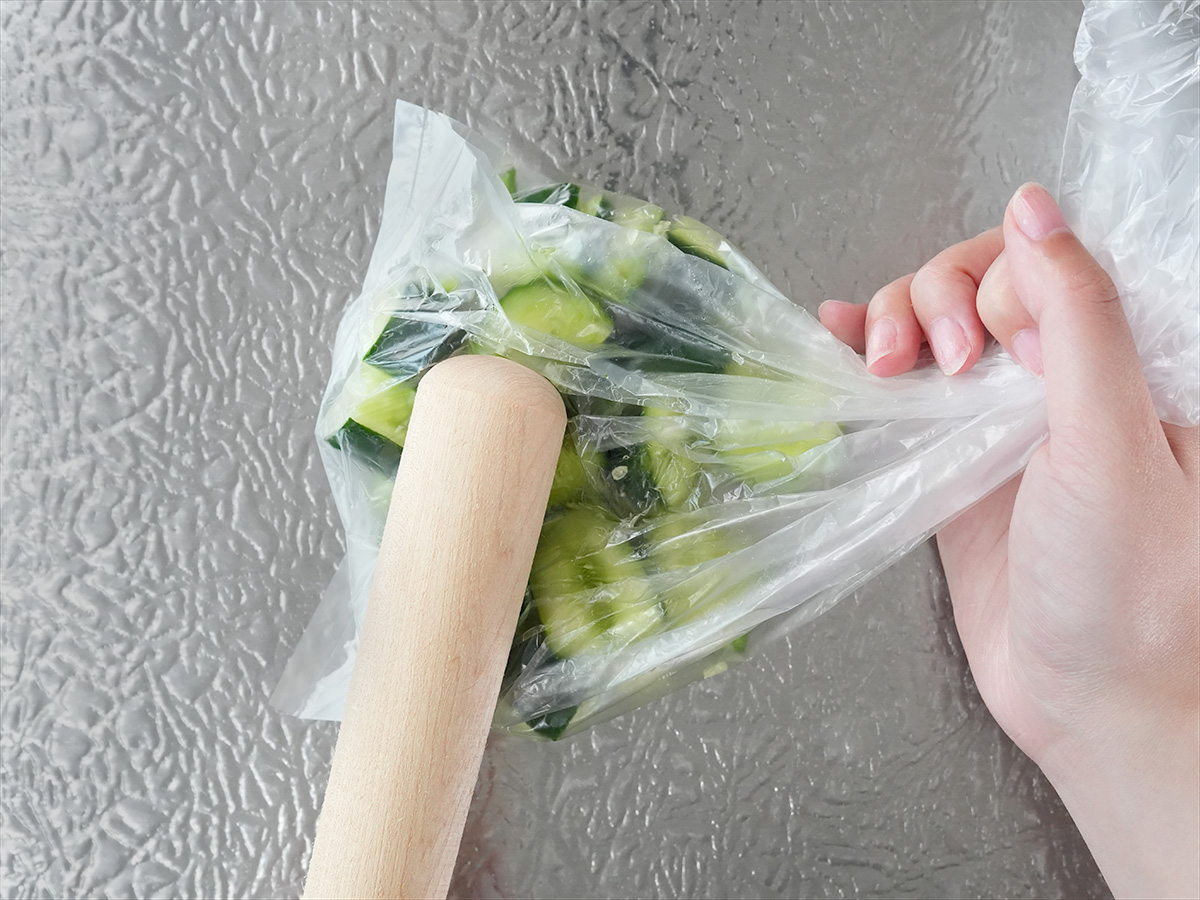 ポリ袋にきゅうりを入れ、袋の上から麺棒で叩くシーン