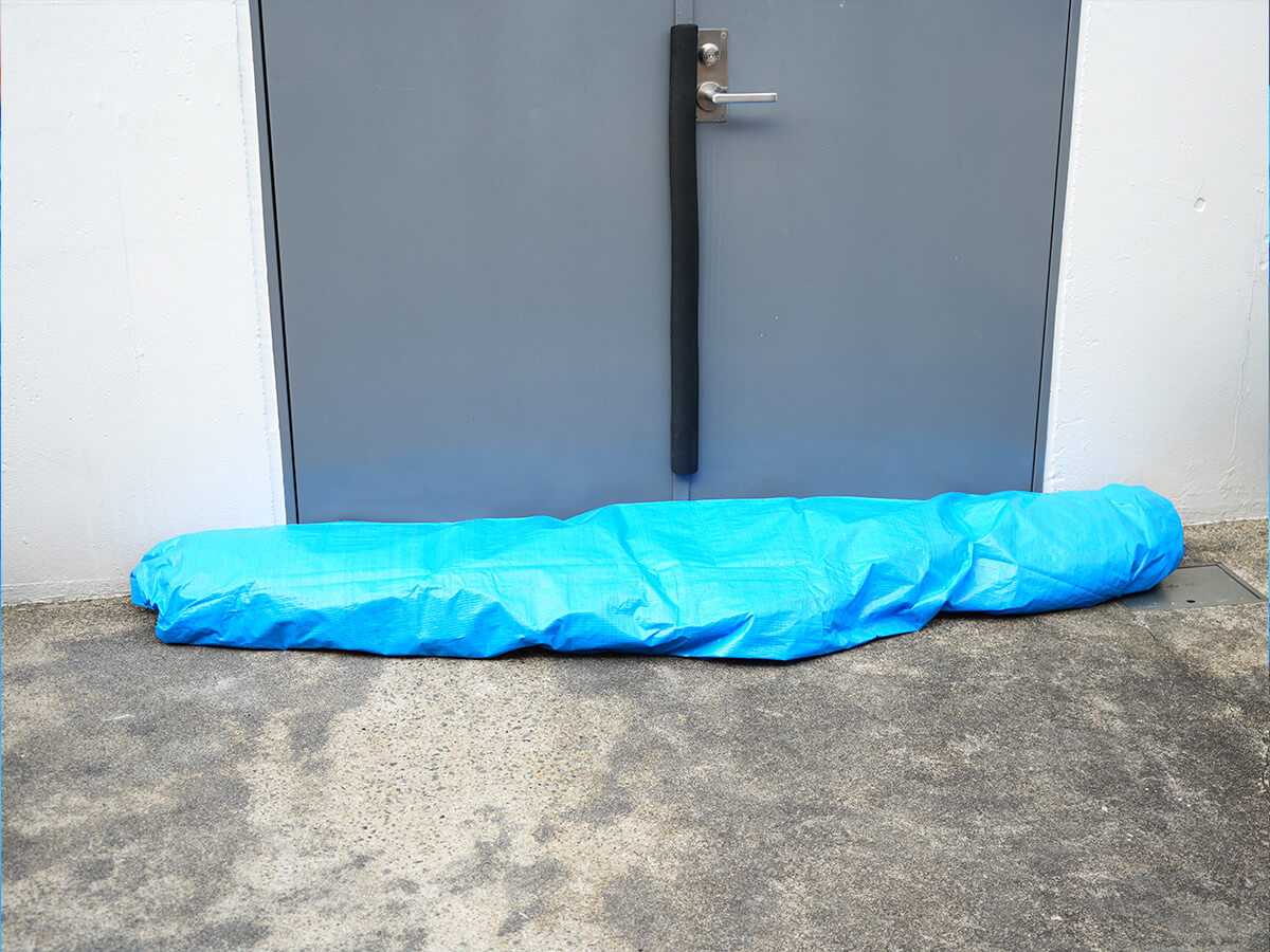 水のうをブルーシートで包む