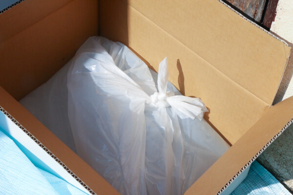 水のうを段ボールとブルーシートで固定