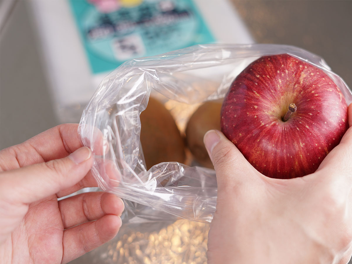食品保存袋にキウイフルーツとりんごを入れている写真